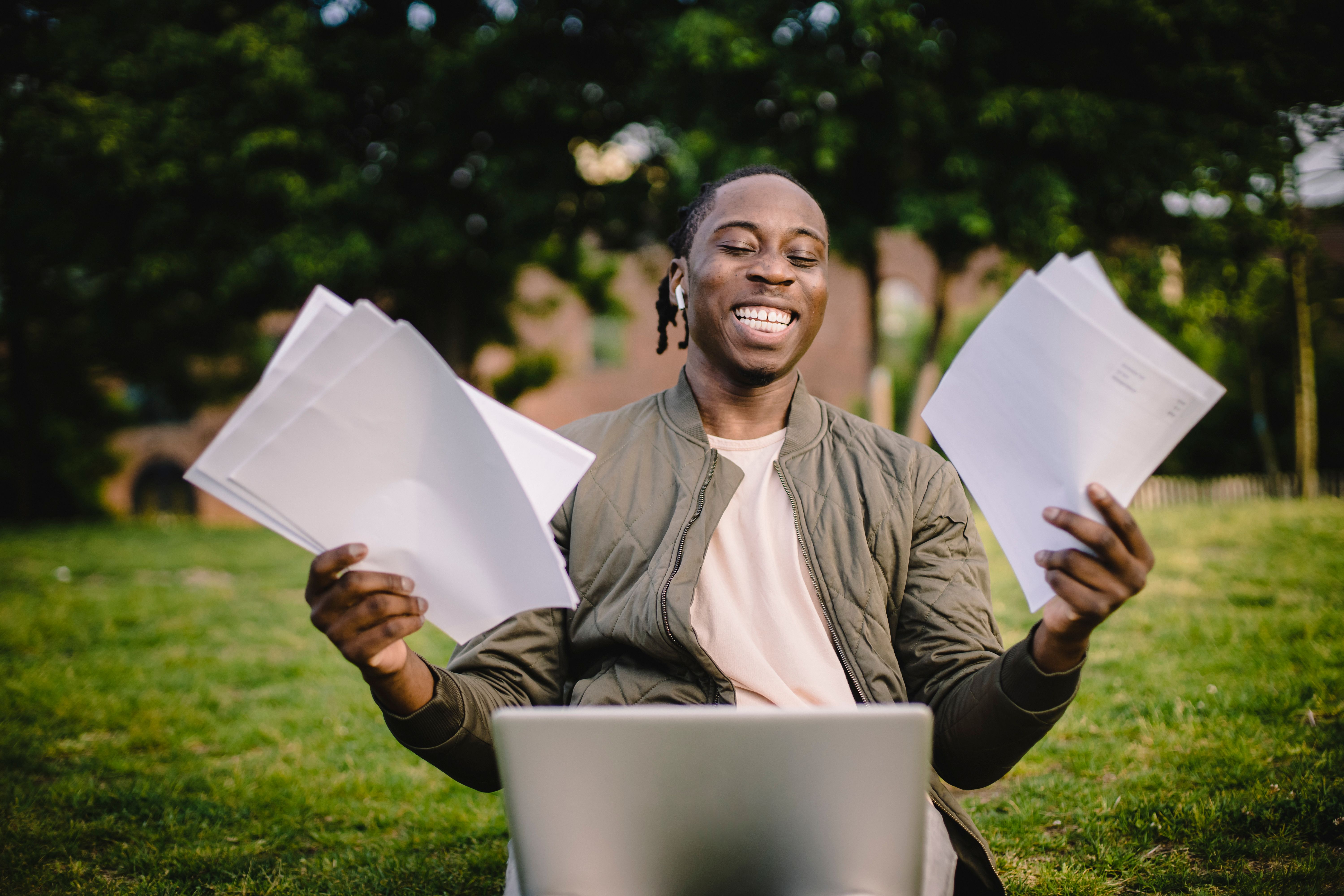 A student reviews university documents beside a laptop