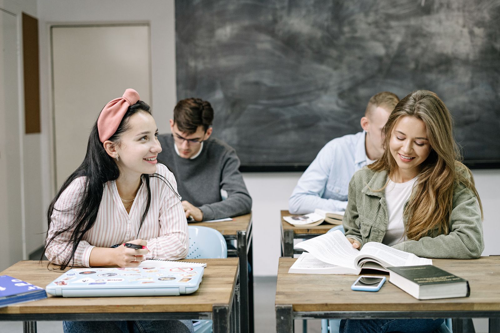 Students in a classroom setting, focused and smiling while engaged in learning activities
